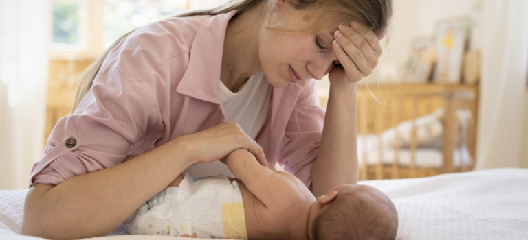 Mom gently drying a baby’s neck to reduce irritation