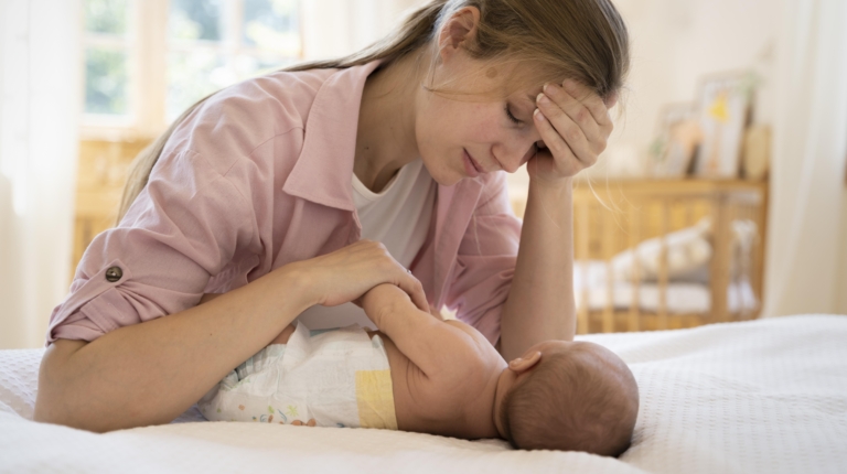 Mom gently drying a baby’s neck to reduce irritation