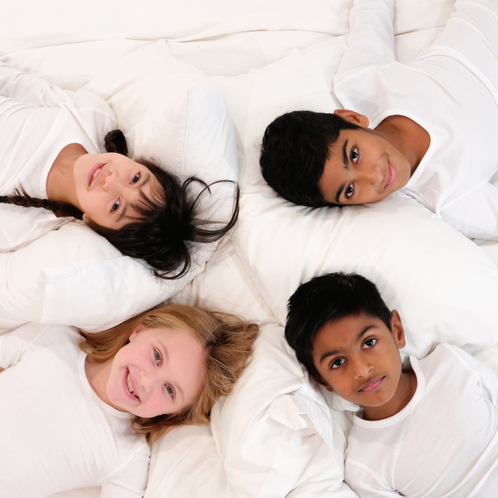 happy children in soothing eczema sleepwear lay on the bed